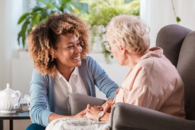 A caregiver speaks with an elderly patient
