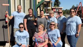 A team of volunteers poses for a photo in a construction environment