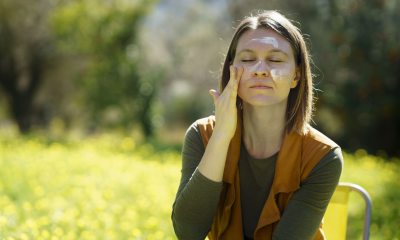 Woman putting face cream on her face.