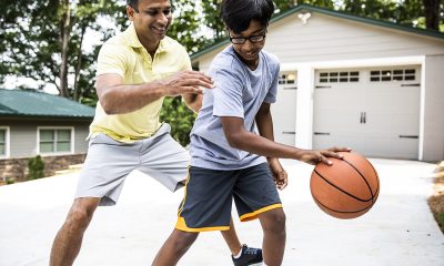 Adult and kid playing basketball.