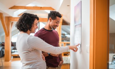 Pregnant woman and partner look together at a wall calendar