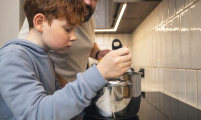 Boy and dad stir a pot of soup