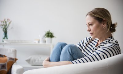 Woman on a couch looks off into space