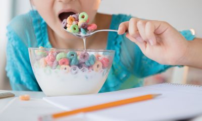 Close-up of child's hand putting a spoonful of kids' cereal in mouth