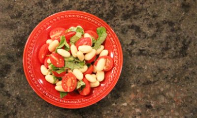 Mediteranean bean salad in an orange bowl