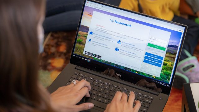 A person on a laptop types while viewing the My PeaceHealth login screen