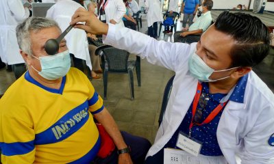 A PeaceHealth provider examines the eyesight of a PazSalud patient