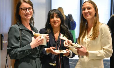 Three women smile and pose for a photo at Women of Peace event