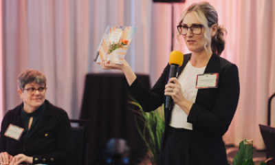 Amber Asbjornsen holds up a card while speaking at Women of Peace event