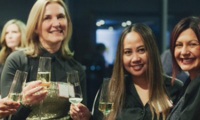 Three women at Women of Peace event smile and share a toast